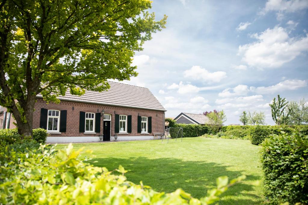 a brick house with a large lawn in front of it at B&B La Rue de France in Sevenum