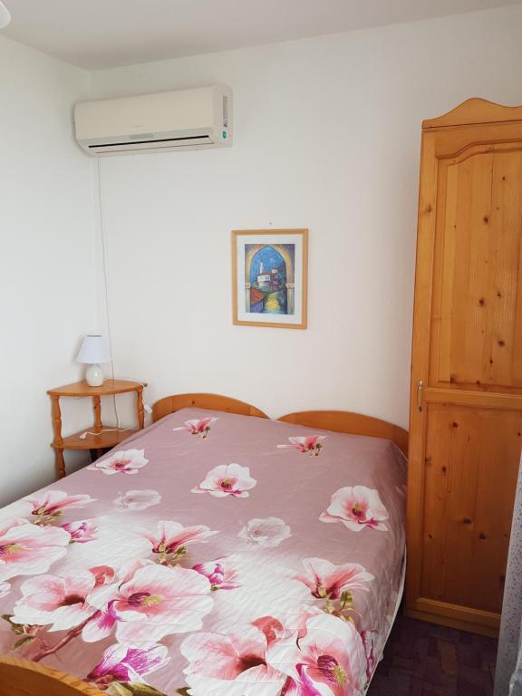 a bedroom with a bed with pink flowers on it at Guest Rooms Radost in Balchik