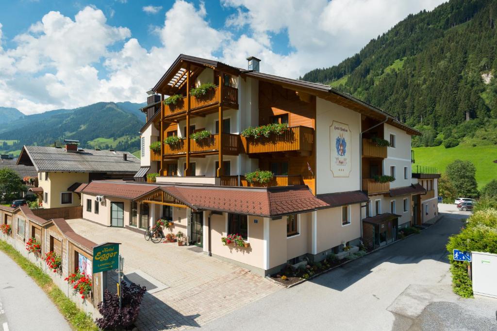 un edificio con fiori sui balconi in montagna di Hotel-Pension Egger a Grossarl