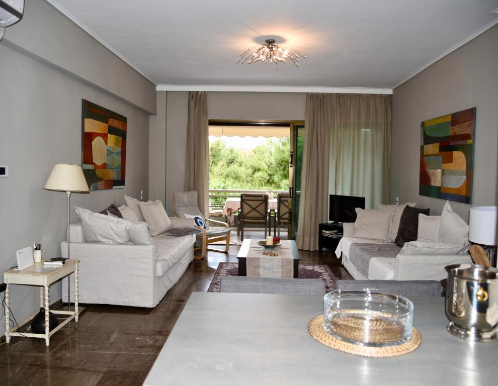 uma sala de estar com sofás brancos e uma mesa em Amazing Apartment em Atenas