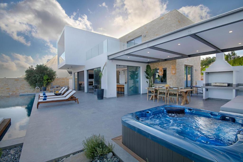 a patio with a swimming pool and a house at Elea Silver Villa in Peyia