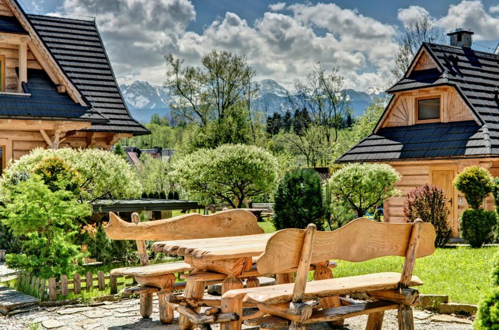 a wooden table and chairs in front of a house at Osada Harenda in Zakopane