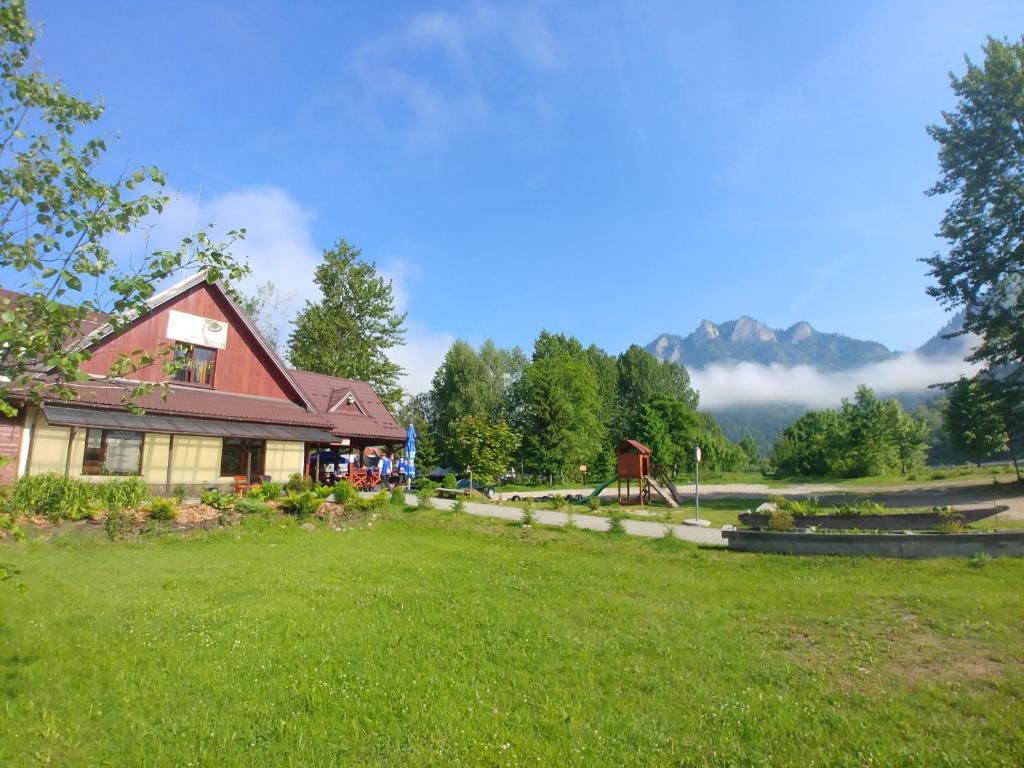 a house in a field with a grass yard at Apartament Nad Dunajcem in Sromowce Niżne