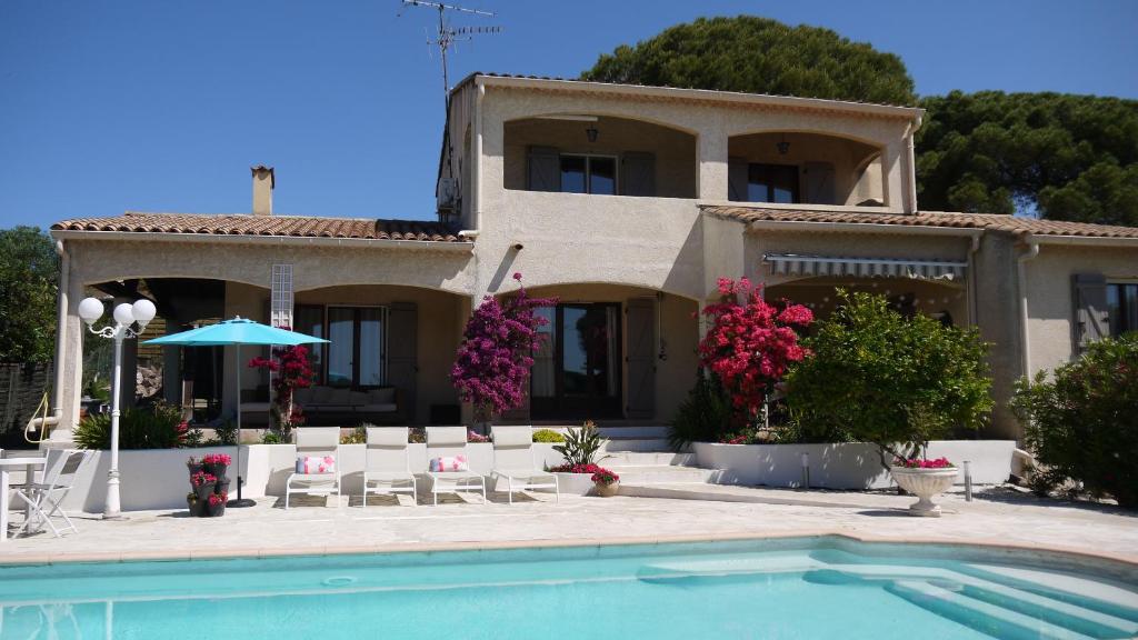 une maison avec une piscine devant une maison dans l'établissement Grand Appartement dans Maison avec Piscine Privée, à Fréjus
