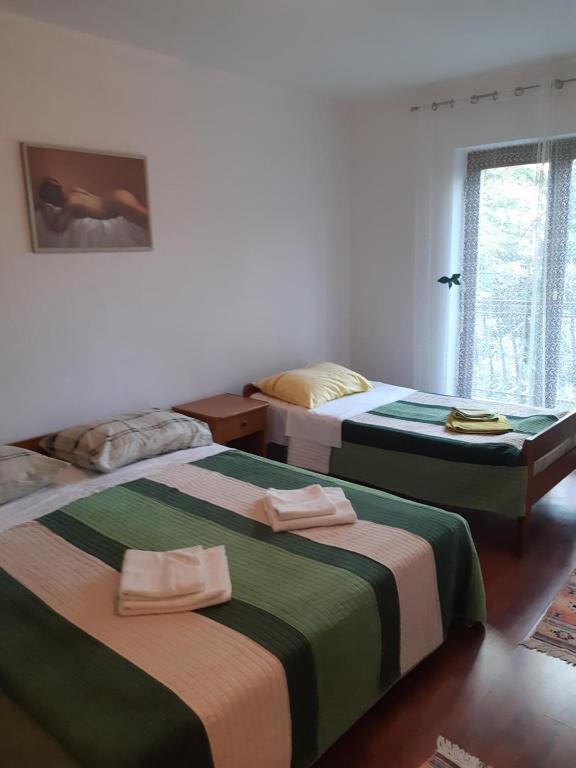sypialnia z 2 łóżkami i ręcznikami w obiekcie Apartments Vukelić w mieście Starigrad-Paklenica