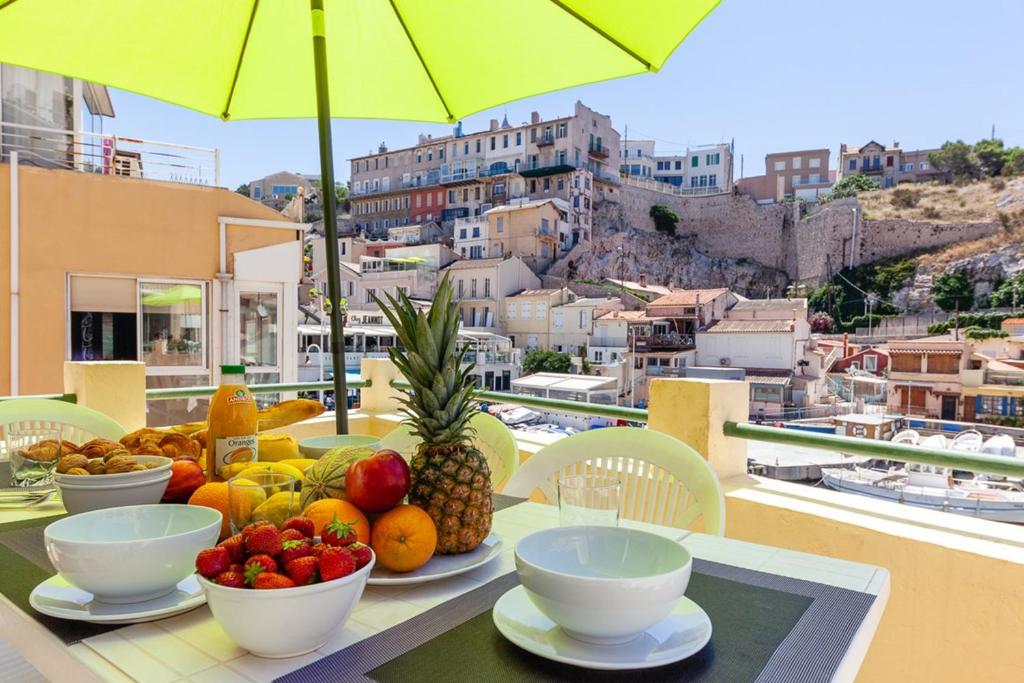 a table topped with bowls of fruit on a balcony at Au Vallon -Terrasse de Rêve sur le Vieux Port in Marseille