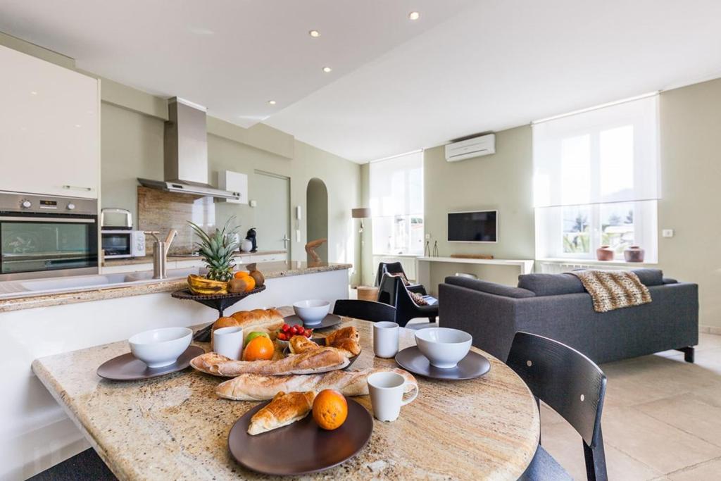 - une table avec du pain et des fruits dans le salon dans l'établissement Le Protis, à Marseille