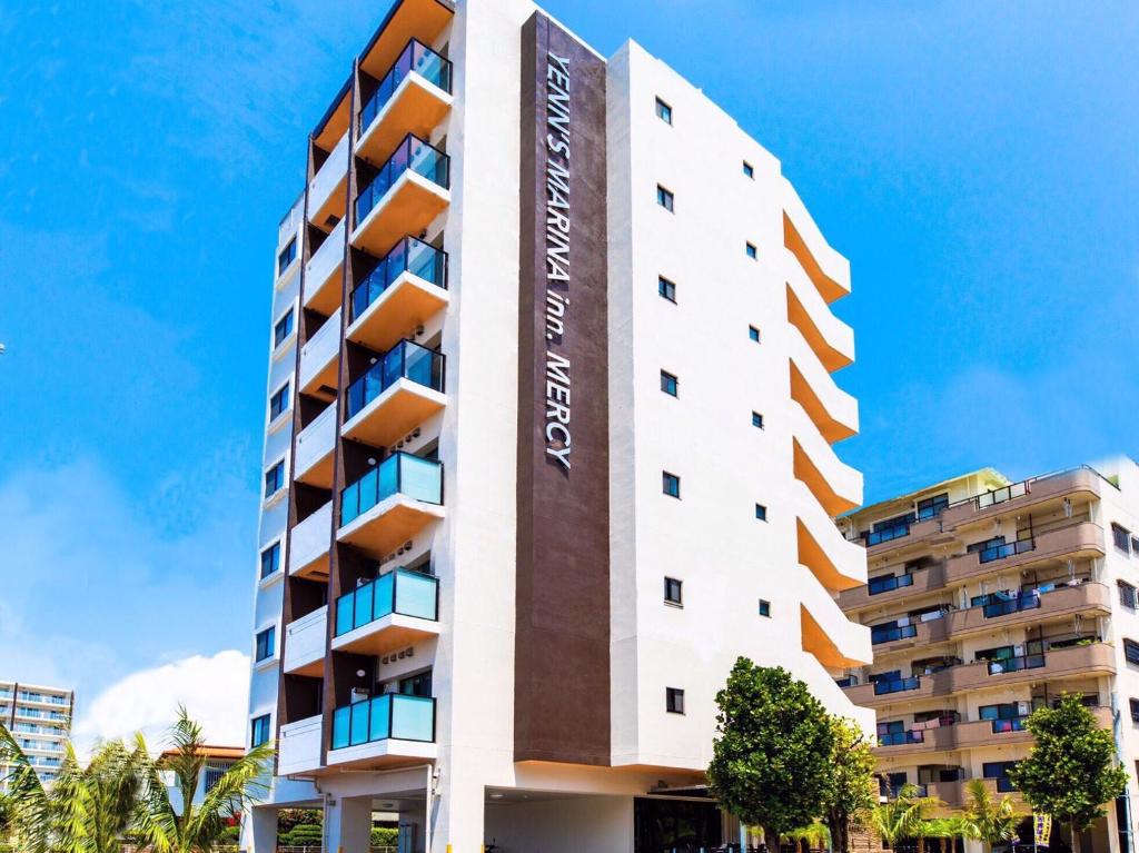 a building with the name of the hotel at Yenns Marina Inn Mercy in Ginowan