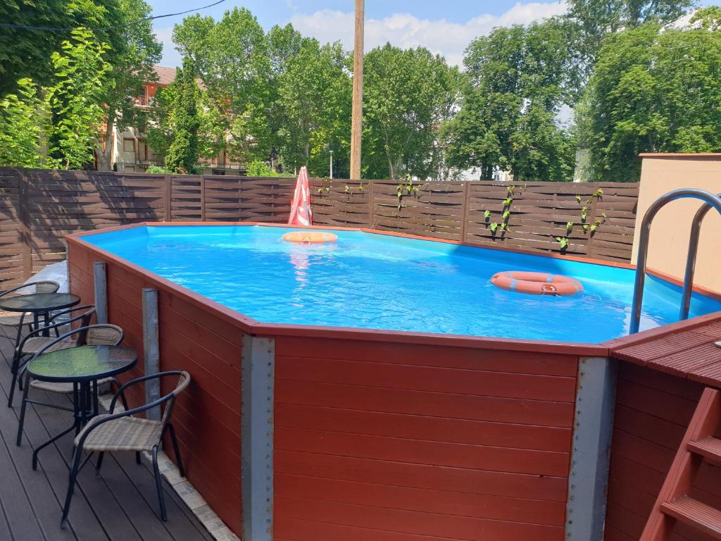 una gran piscina con mesa y sillas en New Beachapartman, en Siófok