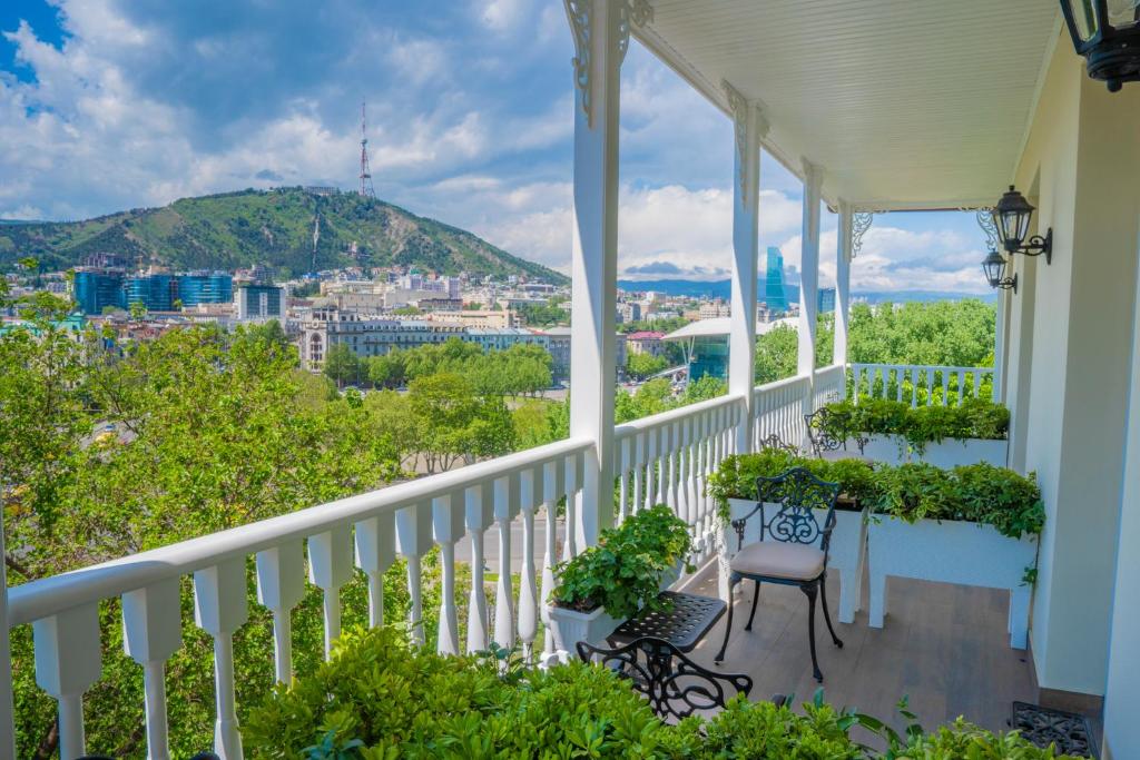 a balcony with chairs and a view of a city at Hotel Passport Tbilisi in Tbilisi City