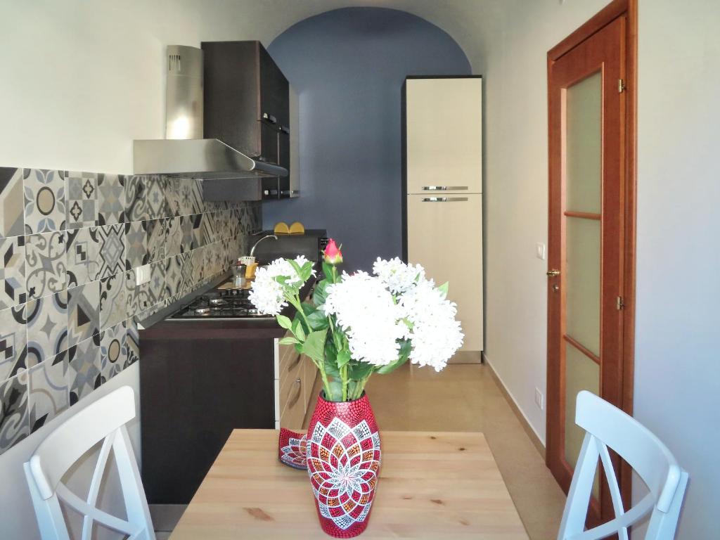 una cocina con una mesa con flores blancas en un jarrón en Casa Vacanze Donna Lucia en Scoglitti
