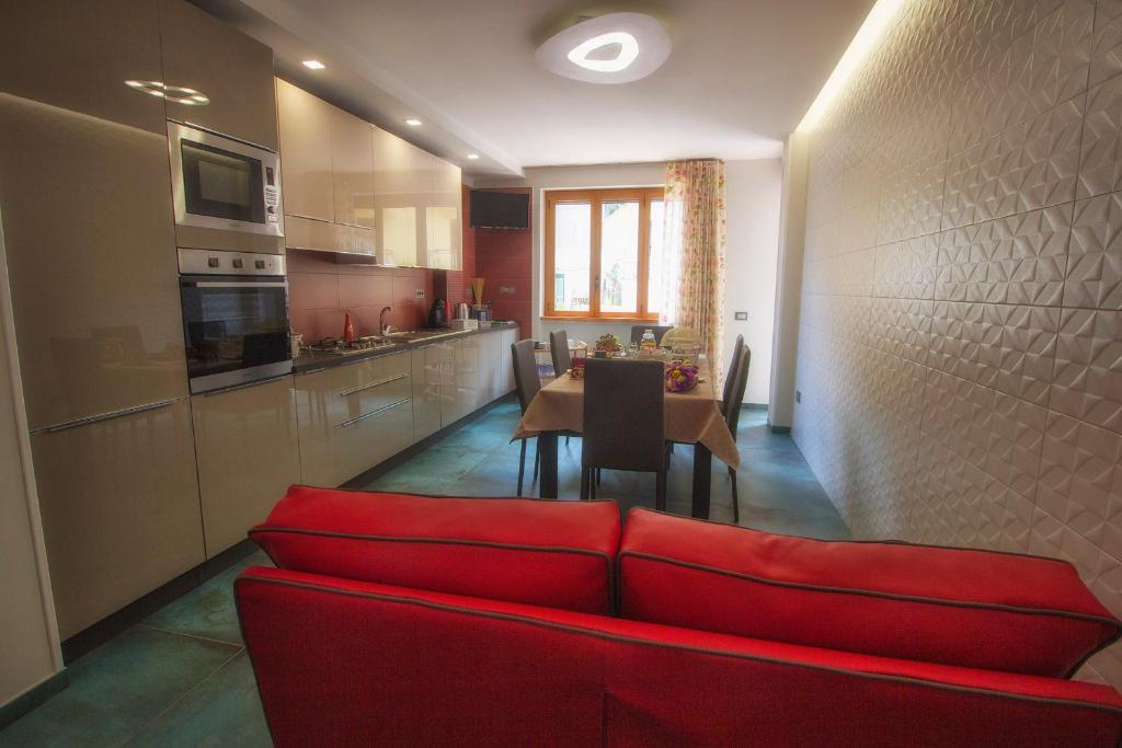 un soggiorno con divano rosso e una cucina di B&B Carol a Cetara