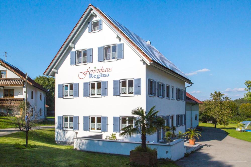 - un grand bâtiment blanc avec un panneau dans l'établissement Ferienhaus Regina, à Walkertshofen