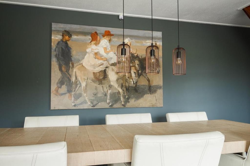 a dining room with a painting on the wall at Vakantiehuizen 7Huizen aan Zee in Scharendijke