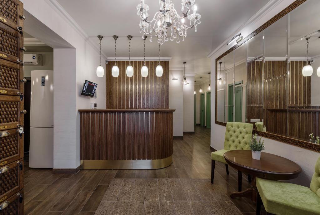 a lobby with a table and chairs and a chandelier at Bon Son Hotel and Hostel Центр in Voronezh