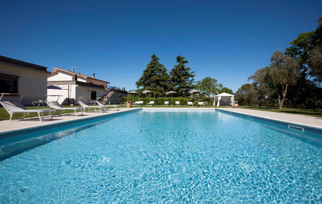 een zwembad met stoelen en een huis bij B&B Sentimento del tempo in Viterbo