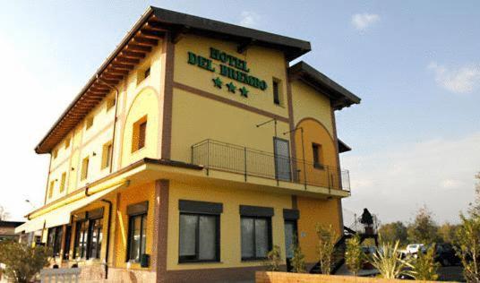 d'un grand bâtiment jaune avec un panneau. dans l'établissement Hotel Del Brembo, à Osio Sotto