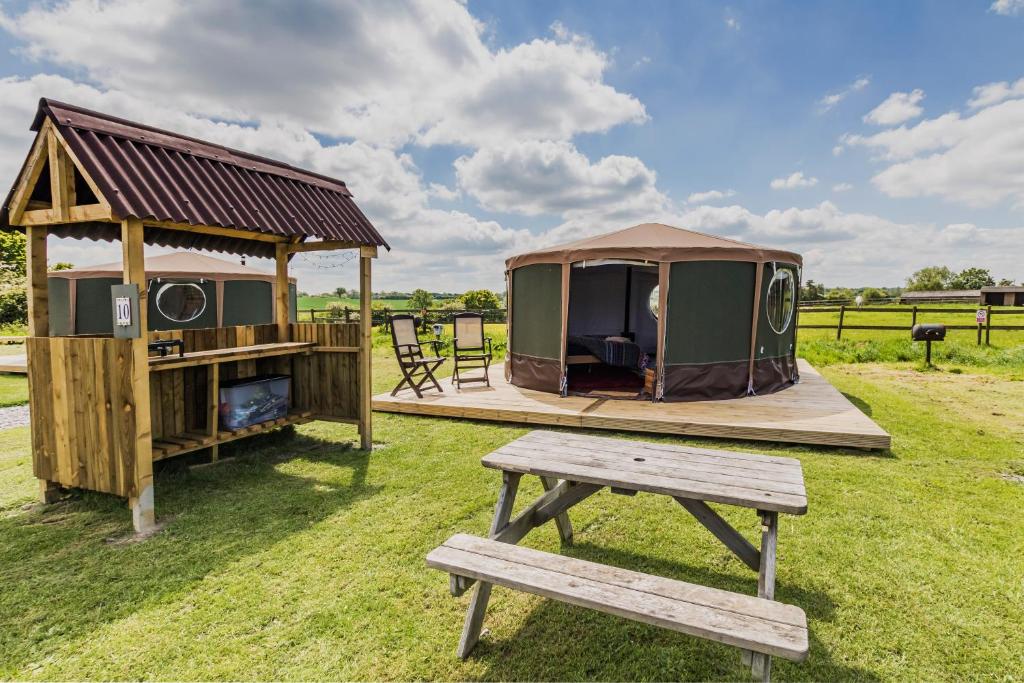 a picnic table and a gazebo and a bench at Mousley House Farm Campsite and Glamping in Warwick