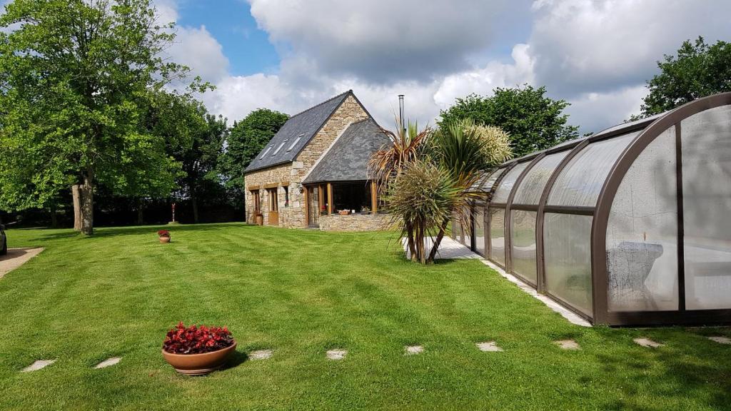 une maison verte avec une plante dans une cour dans l'établissement L Eskemm, à Plouaret