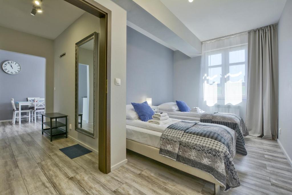 1 dormitorio con espejo grande y cama en Apartament Gemini, en Dzierżoniów