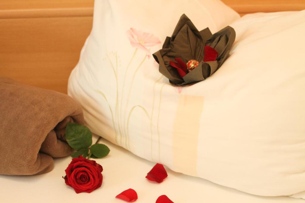 un animal de peluche está sentado en una cama con rosas en Ferienwohnungen Anita, en Fieberbrunn