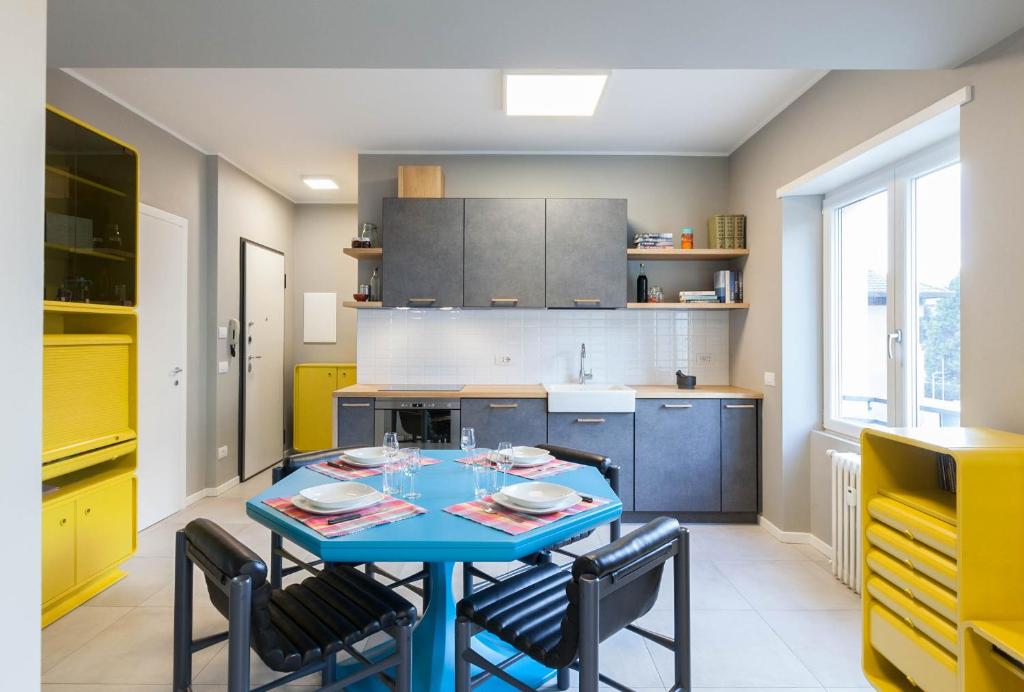 una cucina con tavolo blu e alcune sedie di Appartamento Stelvio a Morbegno