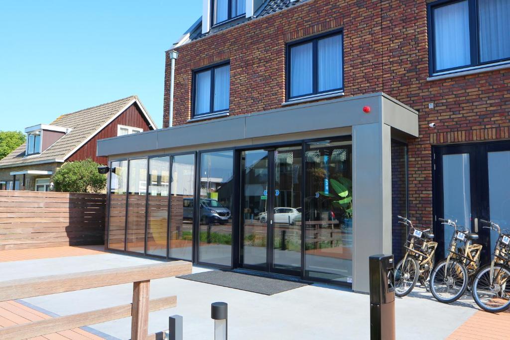 a building with glass doors and bikes parked outside at Blue Mansion Hotel in Aalsmeer