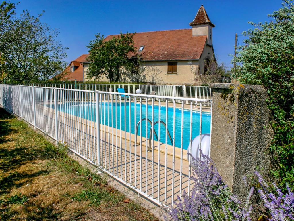 a fence around a swimming pool next to a house at Holiday Home Le Pigeonnier by Interhome in La Valade