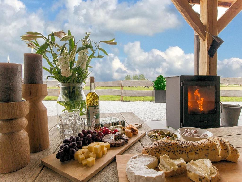 un tavolo in legno con pane e una stufa con camino di Beautiful holiday farm in Holten a Holten