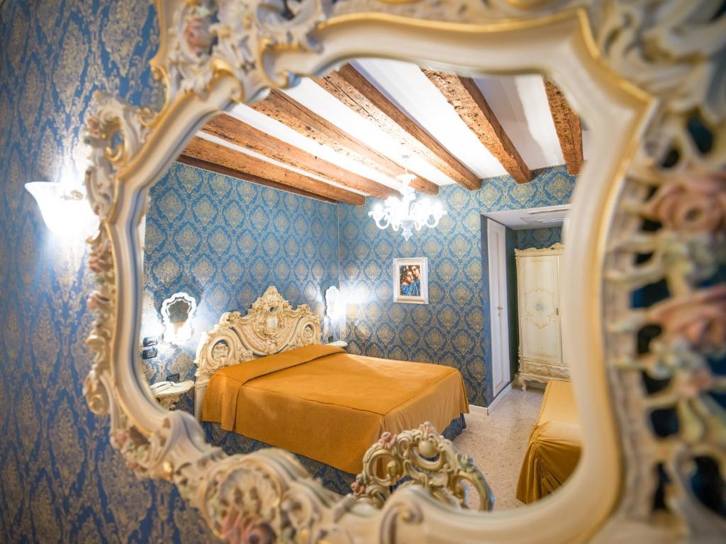 espejo reflejo de un dormitorio con cama en Dimora Marciana, en Venecia