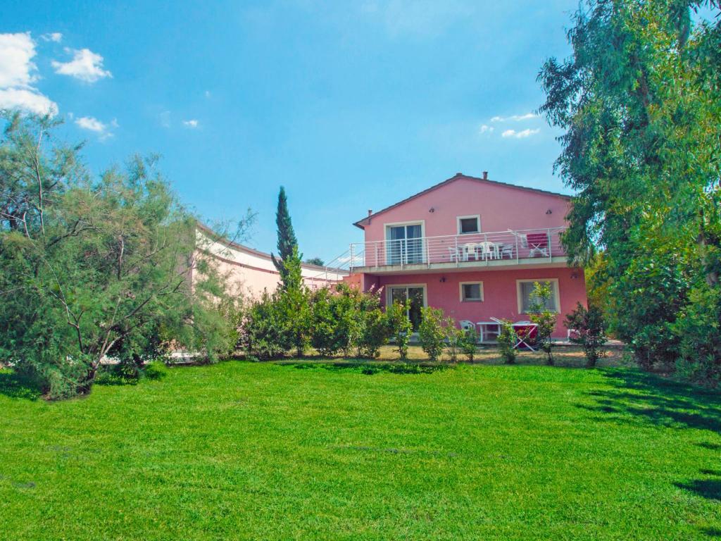 una casa rosa con un patio delante en Apartment Relais-1 by Interhome, en Marina di Bibbona