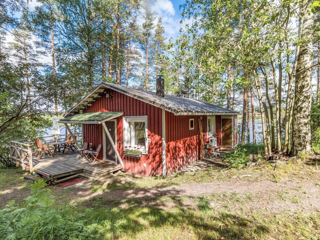 uma cabana vermelha no meio de uma floresta em Holiday Home Artturin mökki by Interhome em Kylmälä