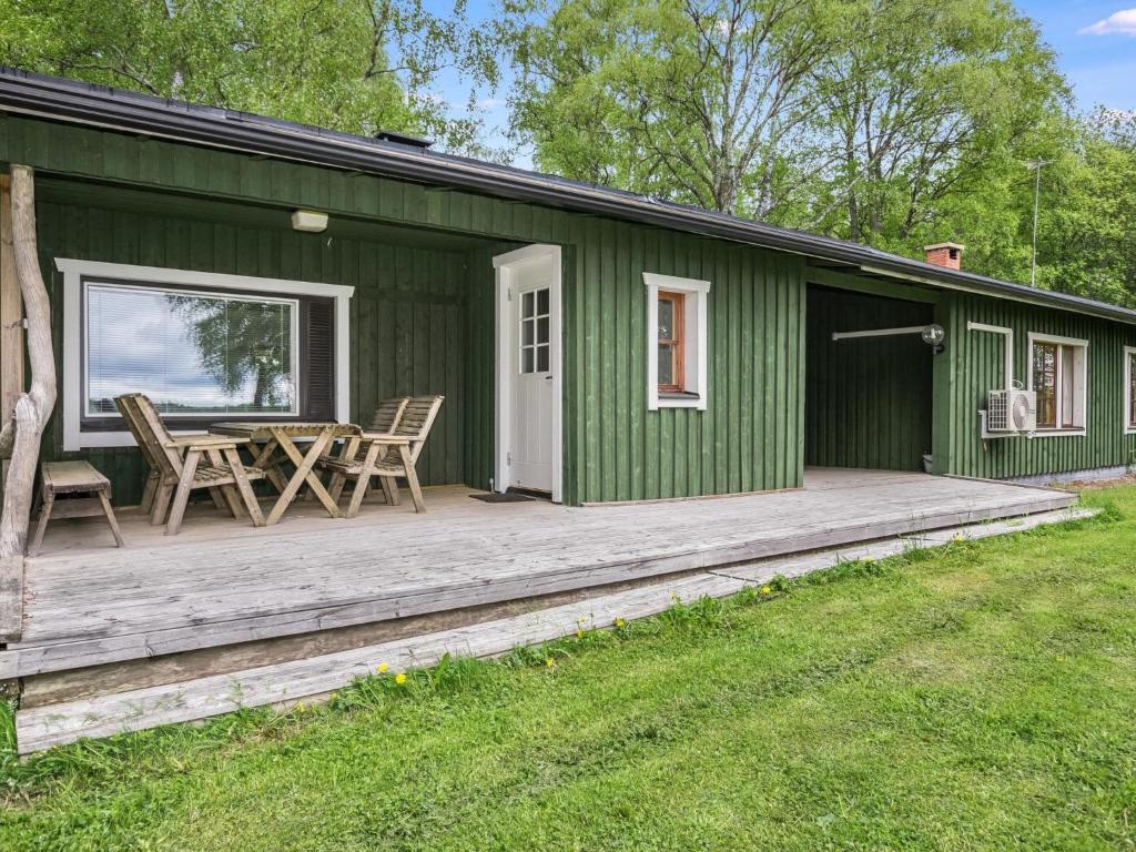 KilvakkalaにあるHoliday Home Ikonen by Interhomeの木製デッキとテーブル付きの緑の家