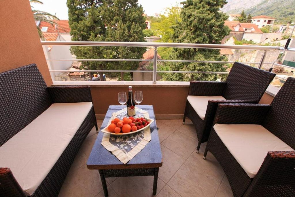 a table with a bowl of fruit on a balcony at Apartments Ezra in Gradac
