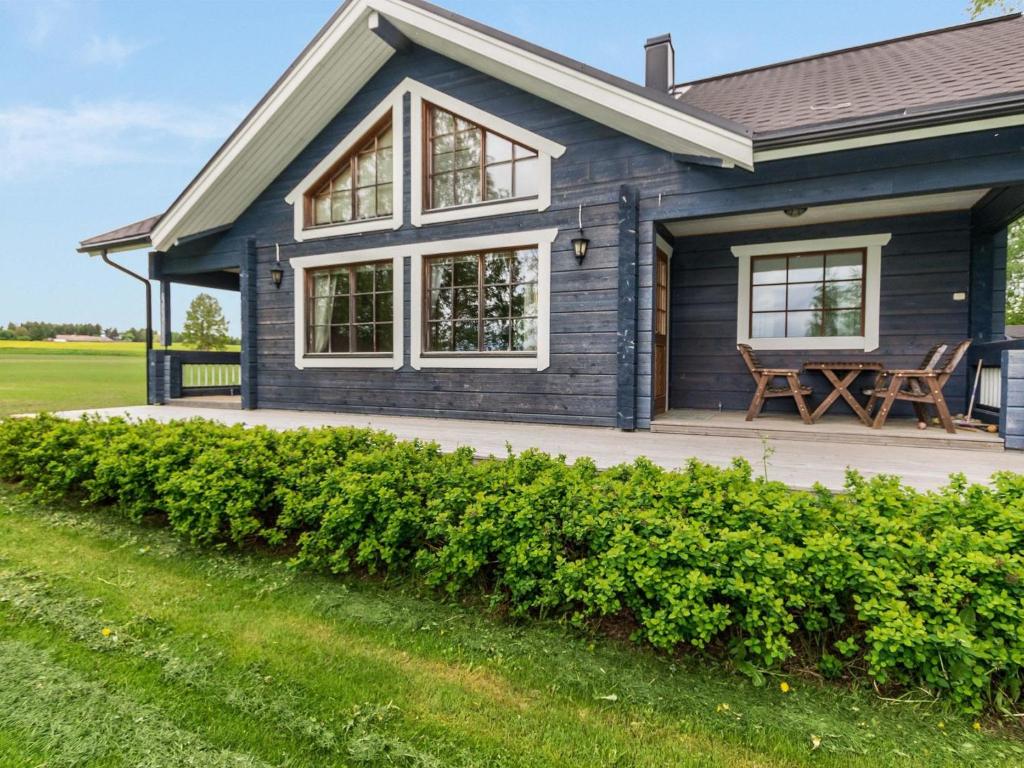 a blue house with a bench on a porch at Holiday Home Juhala by Interhome in Kilvakkala