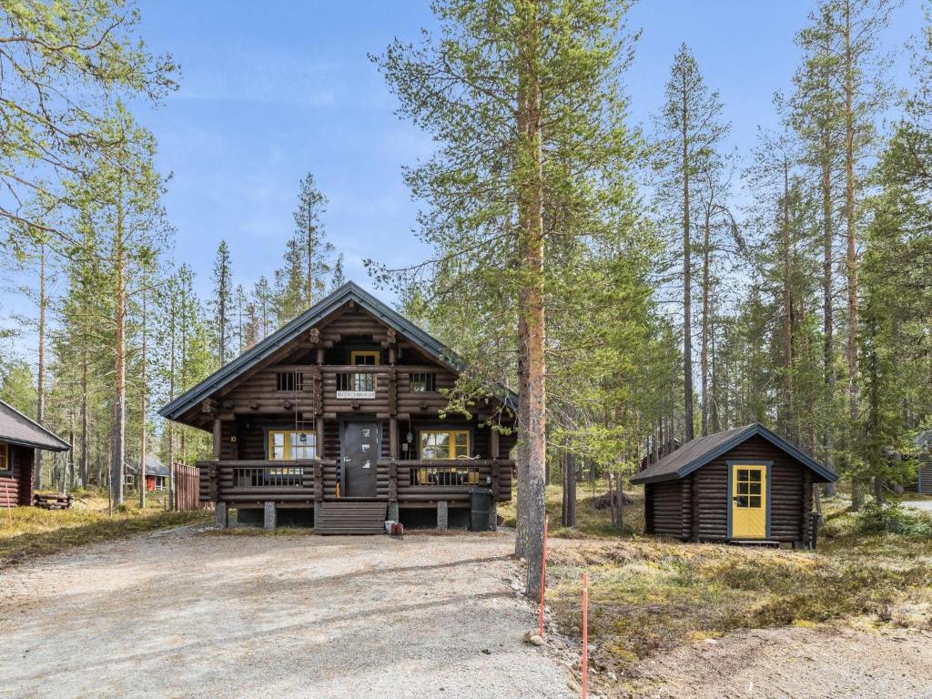 a large log cabin in the woods with a driveway at Holiday Home Riekonmarja by Interhome in Äkäslompolo