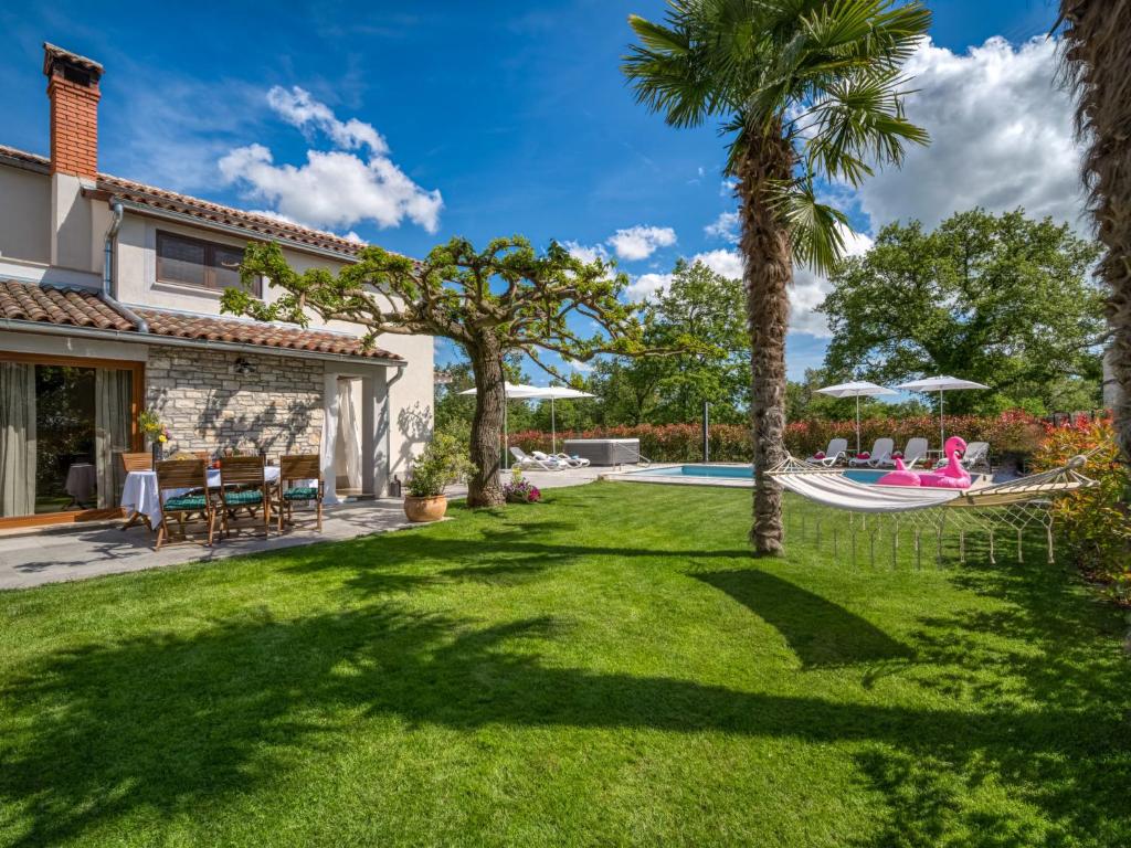 einen Hinterhof mit einer Hängematte und Palmen in der Unterkunft Holiday Home Villa Marina by Interhome in Vošteni