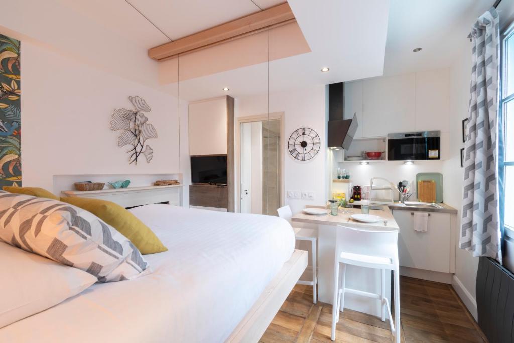 a living room with a white couch and a kitchen at Le Petit Botte in Rennes