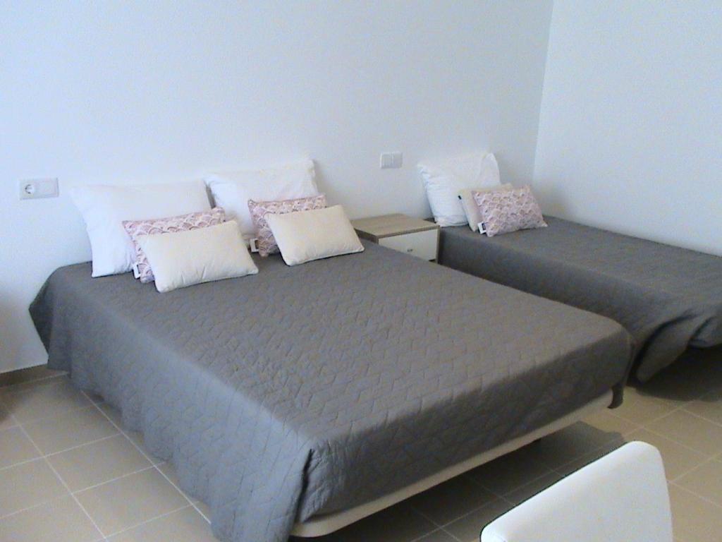 two twin beds in a room with a chair at RM newhost 2015 / CasaDoChico in Portalegre