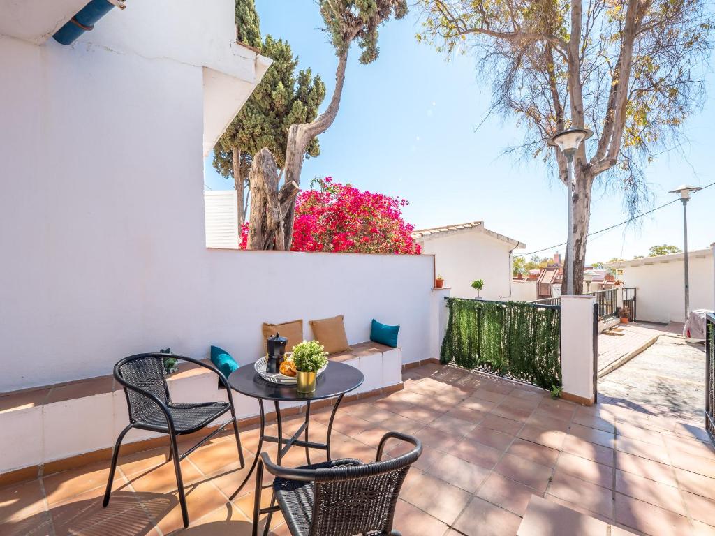 un patio con tavolo, sedie e alberi di SEAFRONT WITH TERRACE a Málaga