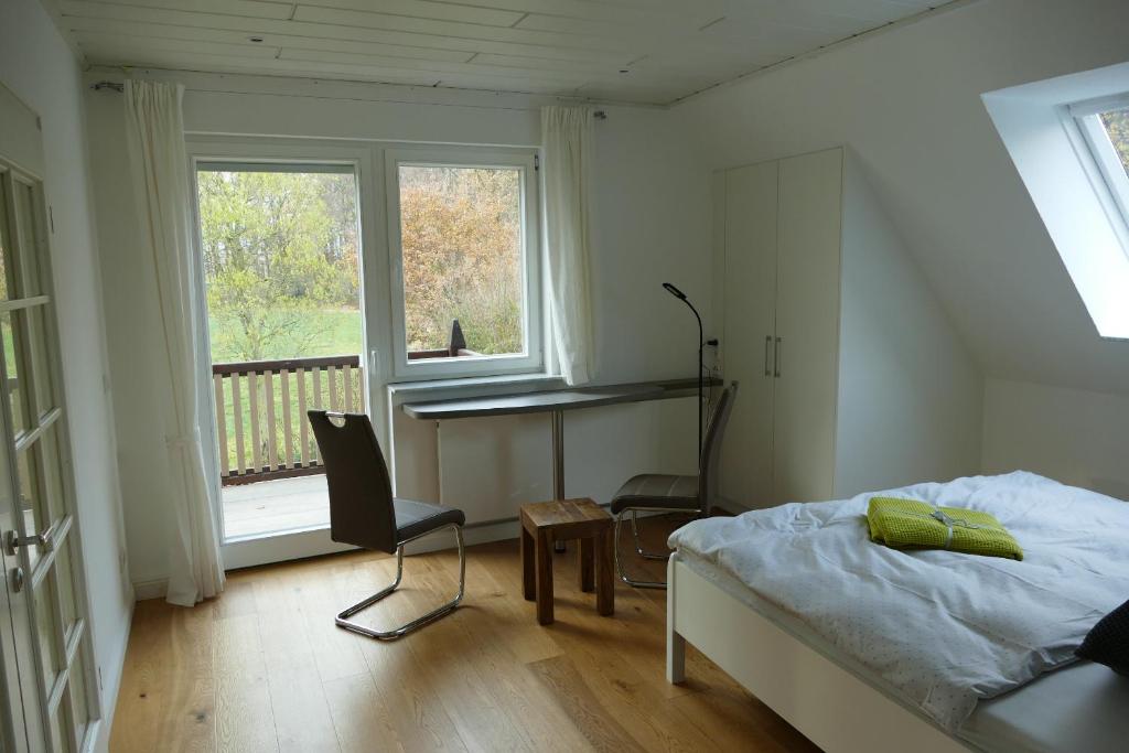 a bedroom with a bed and a chair and a window at Ferienwohnung am Wulfkamp in Velen