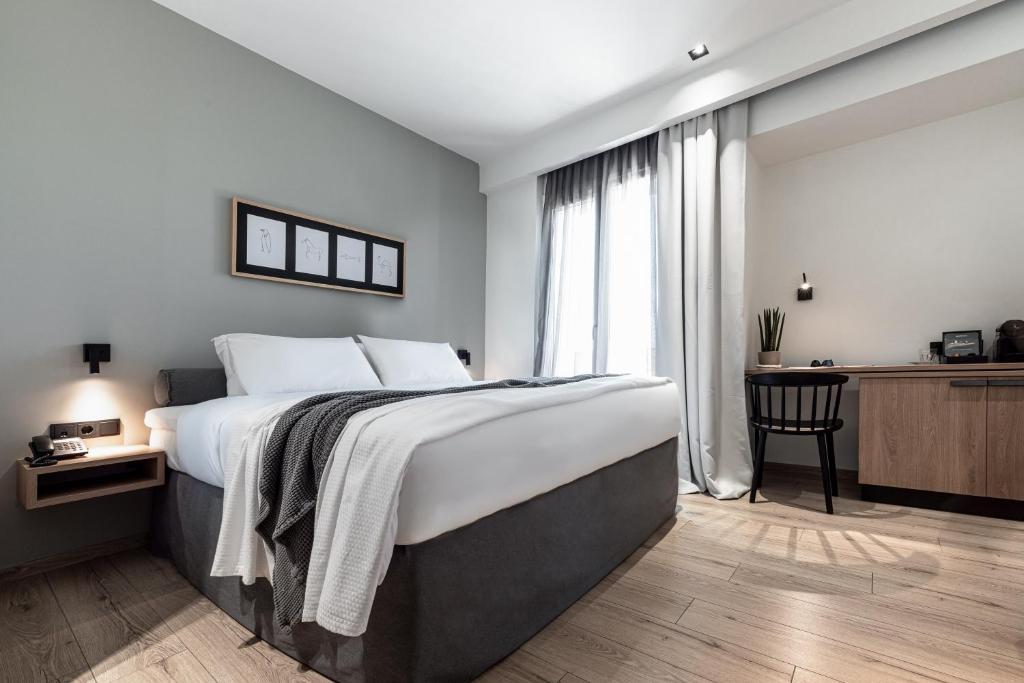 a bedroom with a bed and a desk and a window at 31 Doors Hotel in Alexandroupoli