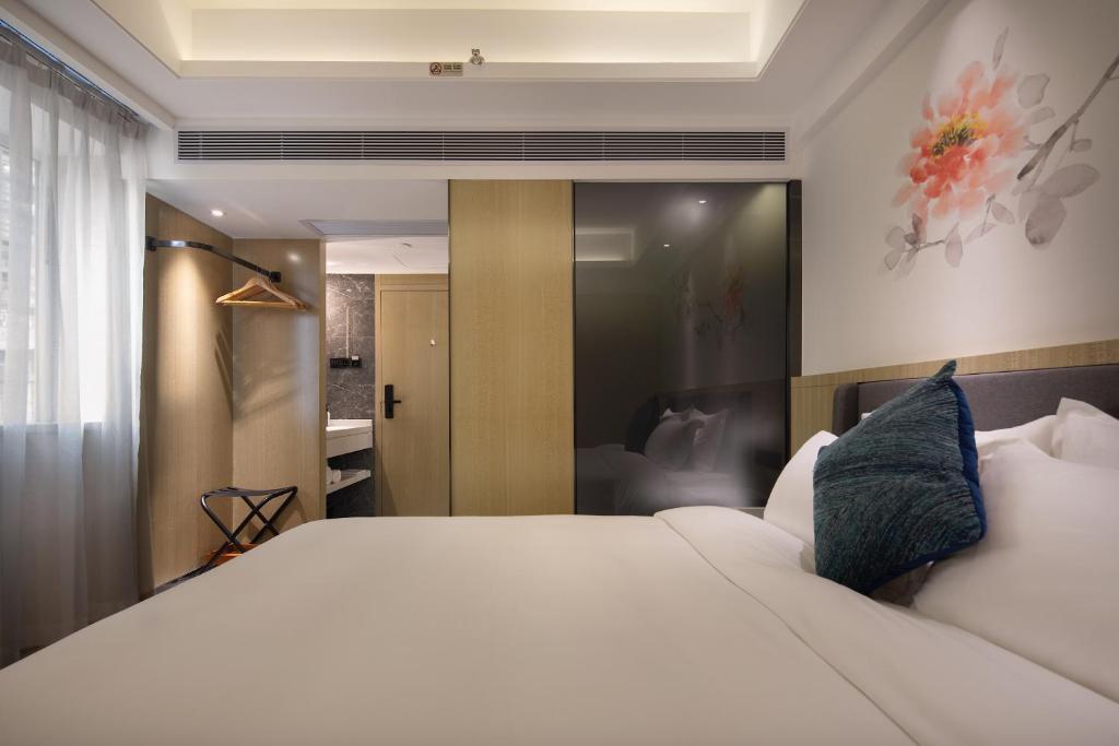 Postel nebo postele na pokoji v ubytování Paco Hotel Guangzhou Jiangtai Road Metro Branch