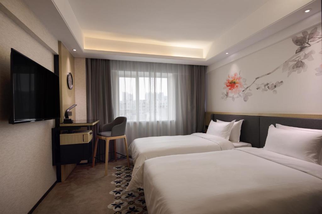Postel nebo postele na pokoji v ubytování Paco Hotel Guangzhou Jiangtai Road Metro Branch
