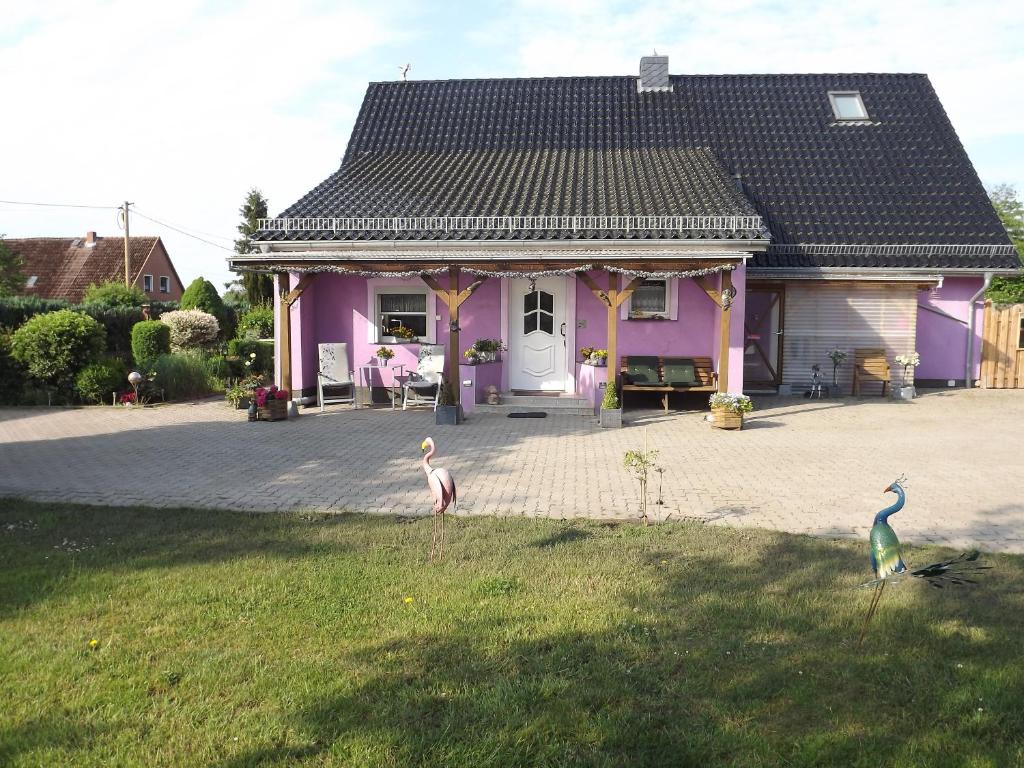 dos pájaros parados frente a una casa púrpura en Ferienwohnung Ostseenähe en Schönberg