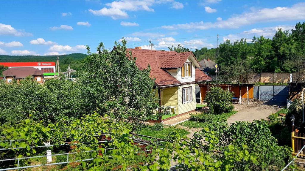 uma pequena casa amarela com um telhado vermelho em Guest house Dom Turista em Kamennomostskiy