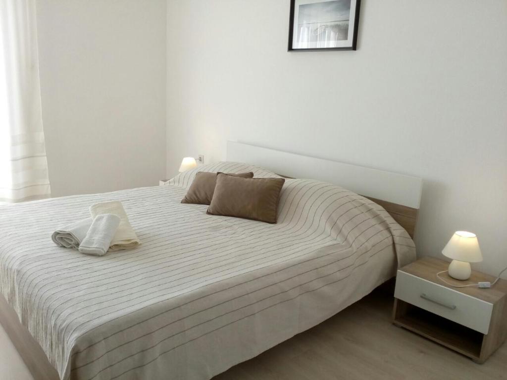 a bedroom with a large white bed with two pillows at Apartman Knapić in Koromačno