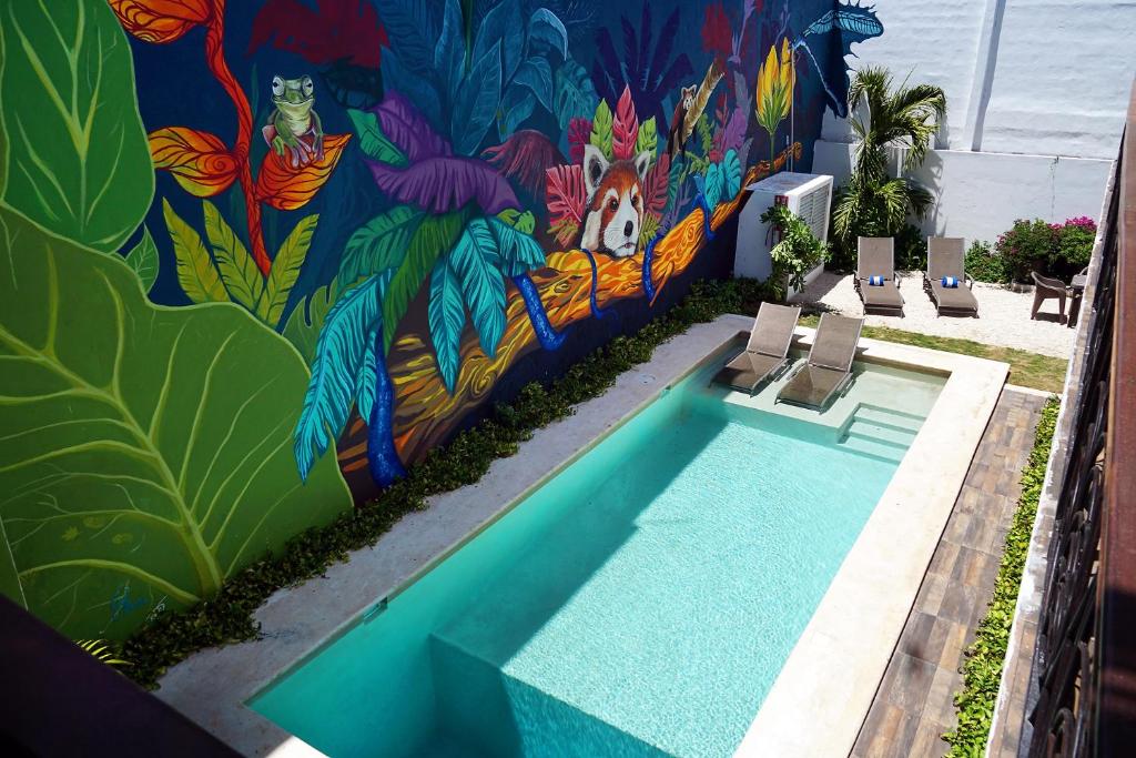 a swimming pool with a mural on the side of a building at Red Panda Hostal in Playa del Carmen