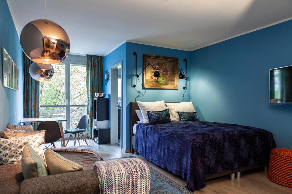 Studio Apartment in Dresden-Neustadt في درسدن: غرفة نوم زرقاء مع سرير وأريكة