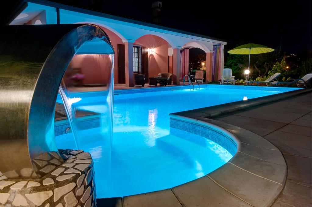 una piscina por la noche con una iluminación azul en B&B Villa Gloriana, en Sona